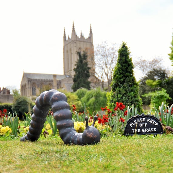 Large Caterpillar Metal Ornament Displayed in a Garden Setting