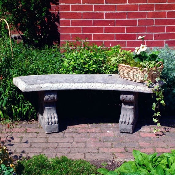 Curved Pattern Stone Garden Bench in natural garden setting with brick paving