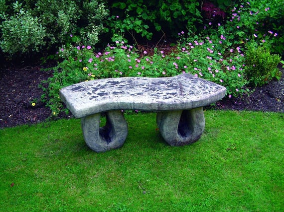 Wealdon Stone Garden Bench with looping legs in garden setting