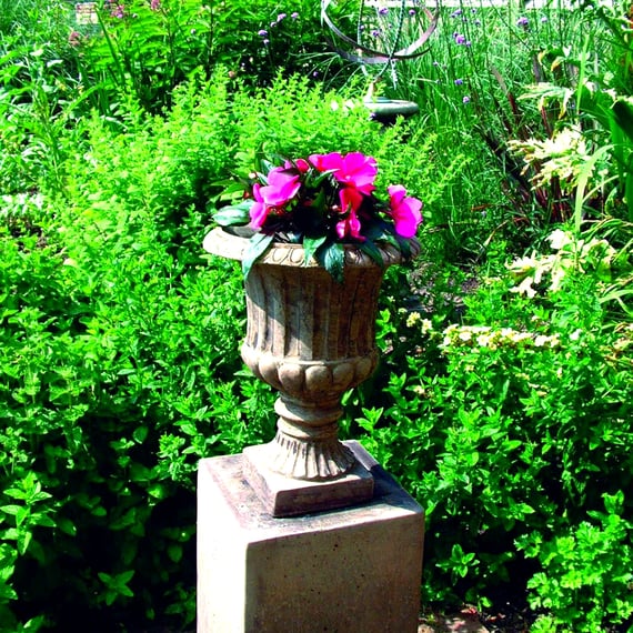 Vienna Fleur Stone Garden Vase in a Garden Setting