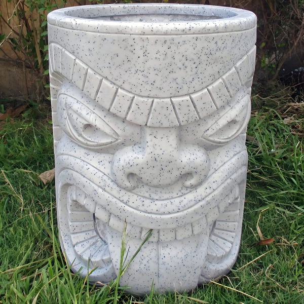 Tiki head granite garden planter with foliage planted in the top