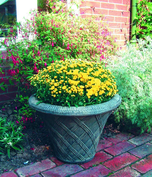 Thatched stone urn raised on a pedestal as a garden focal point