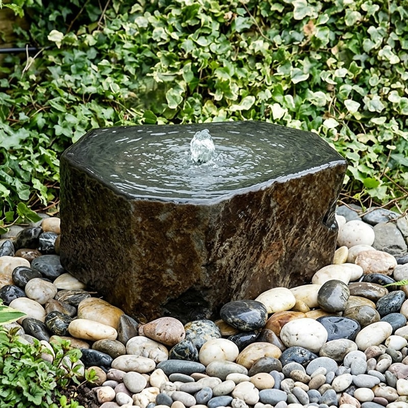 Babbling Basalt Column water feature with dark stone pillar and shallow basin in modern garden setting